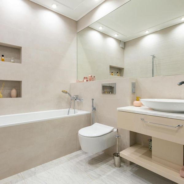 Person stretching gently in a brightly lit room with minimalist decor.